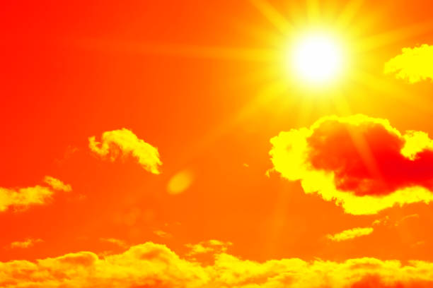 istock Bright sun with beautiful beams in the sky with clouds (toned in red) 1257971344