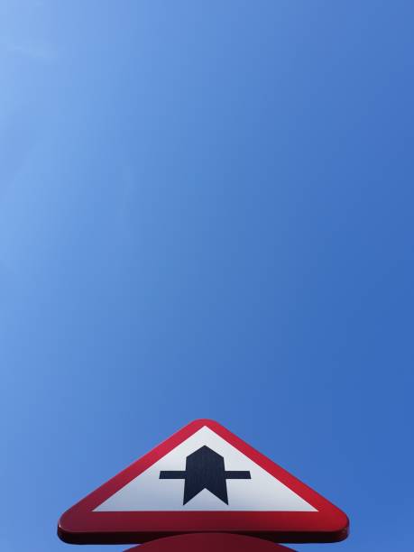 Perspective view of a traffic signal.  Triangular symbol.  Priority intersection notice.  Minimalist colour image. Copy space template. Vertical background texture. Road sign. Metallic sign with blue sky as background. bottom the weaver stock pictures, royalty-free photos & images