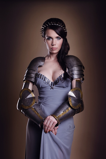 Warrior woman. Fantasy fashion idea. beautiful girl in armor     Portrait of a beautiful lady warrior, dark-haired girl in a gray melting dress. bright makeup, hairstyle, spikes.