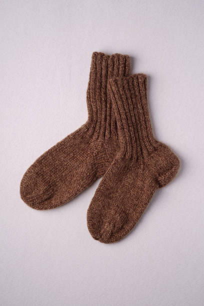istock Brown handmade warm knitted wool socks pair for cold winter, isolated 1257972315