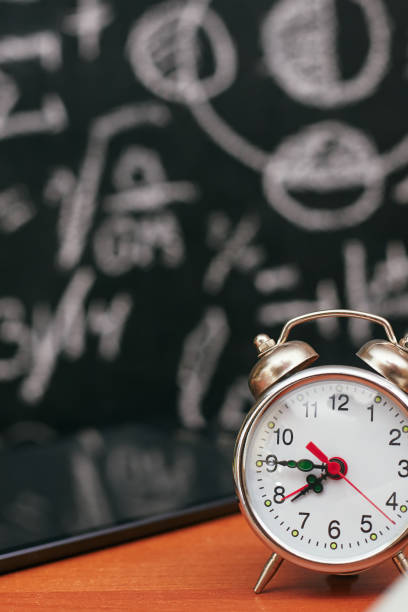 istock back to school concept, alarm clock on school board background, university 1257974236