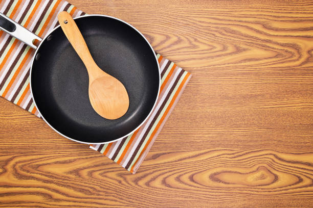 non stick frying pans on wooden background