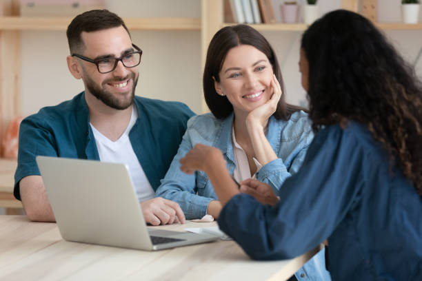 real estate agent consulting happy young couple about buying house. - family insurance agent real estate financial advisor imagens e fotografias de stock