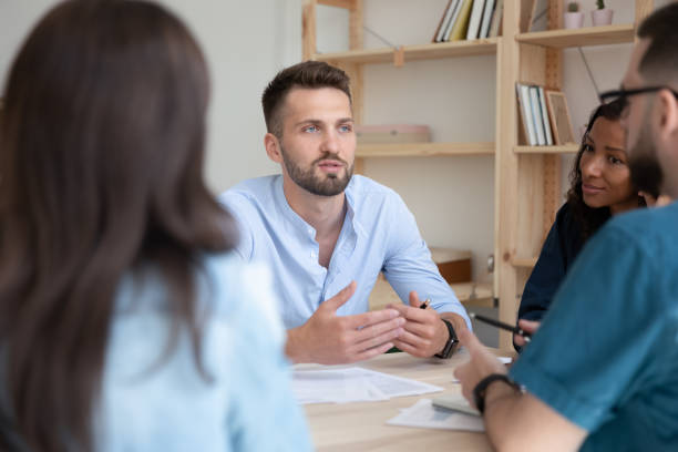 istock Close up serious bearded businessman telling employees about project. 1257975847