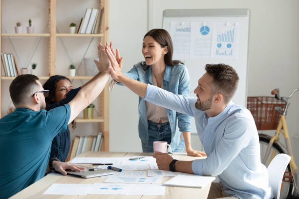 istock Diverse workers with female mentor, coach giving high five. 1257975860