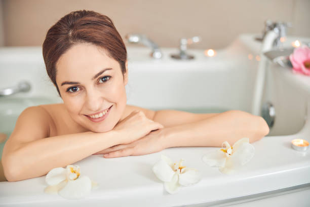 istock Pleasant brunette female is enjoying taking bath 1257975910