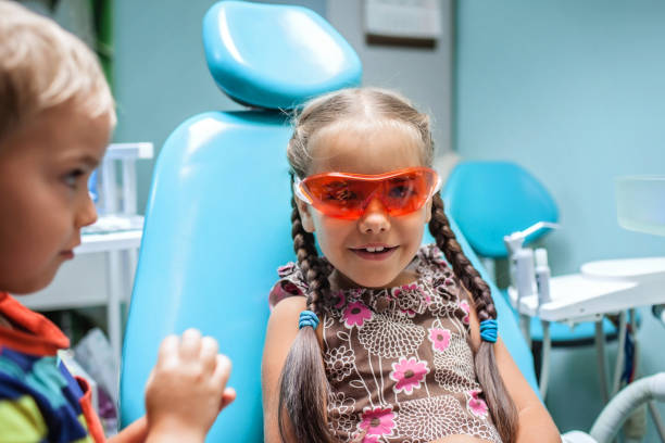 duas crianças se divertindo e usando óculos médicos durante visita ao consultório do dentista - baby boys clothing hospital simplicity - fotografias e filmes do acervo