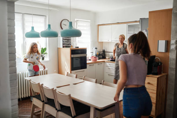 istock Sisters Playing Table Tennis On The Table In The Dining Room 1257980136