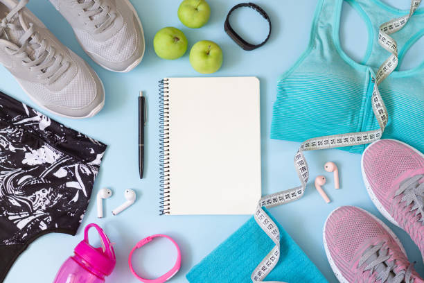 istock Gym wear and accessories for women with blank notebook for exercise plan on blue mat 1257985286