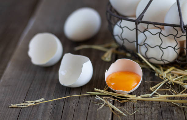 istock Fresh farm eggs with yolk in eggshell wood background 1257985360