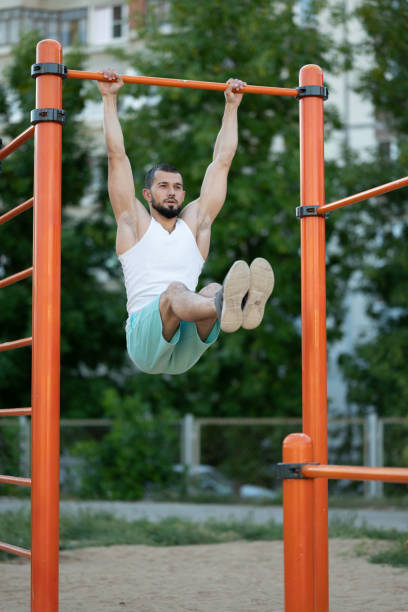 istock fitness, sport, exercising, training and lifestyle concept - man doing abdominal exercise on horizontal bar 1257986267