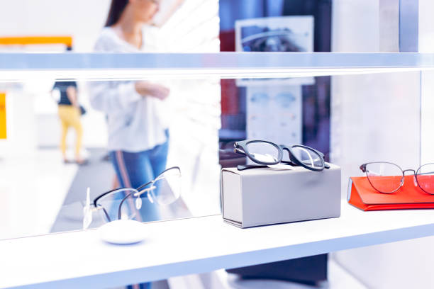 Fashionable eyeglasses on display shelf in retail