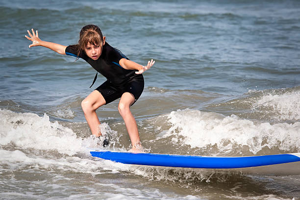 Young surfer girl is riding a wave..