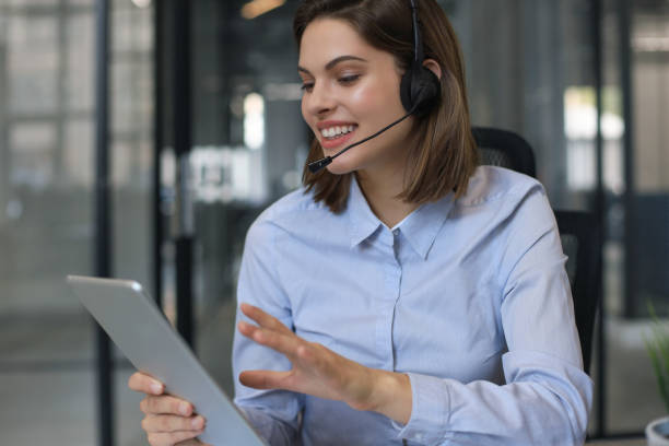 istock Cheerful female manager sitting at office desk and performing corporate tasks using wireless connection on digital gadgets. 1257997702