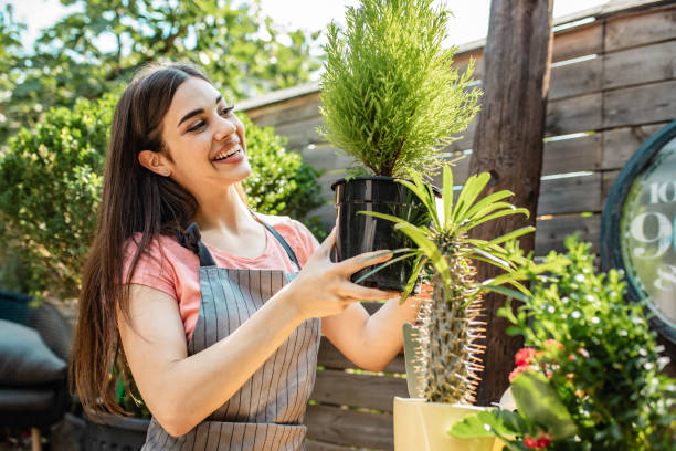 istock Young woman is using gardening tools in back yard 1258001070
