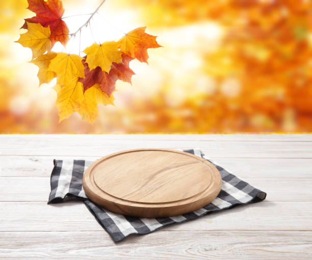 istock Empty pizza board and table cloth on wooden deck table with napkin. Autumn background. 1258001141