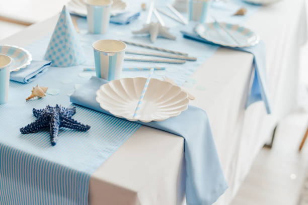 istock Tableware and decorations for serving festive table in sea style. Elegant plates, paper cups, straws, plates 1258001210