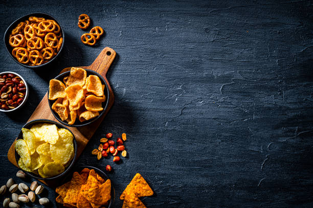 istock Salty snacks assortment shot from above on dark slate table. Copy space 1258002366