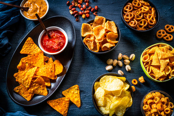 istock Salty snacks shot from above on dark slate background. 1258002417
