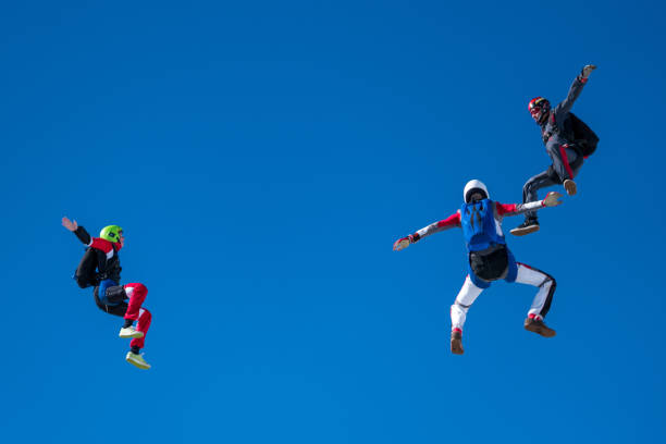Freefall jumpers soar above mountain landscape