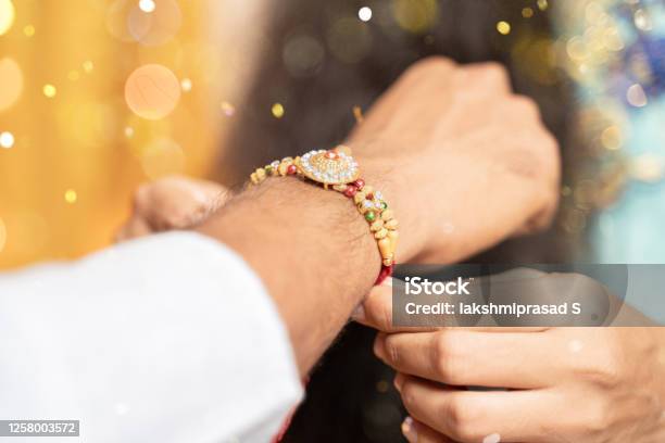 Closeup Of Hands Sister Tying Rakhi Raksha Bandhan To Brothers Wrist During Festival Or Ceremony Rakshabandhan Celebrated Across India As Selfless Love Or Relationship Between Brother And Sister Stock Photo - Download Image Now