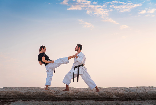 Couple practicing karate outdoors at sunset. Martial arts training for fit and healthy lifestyle