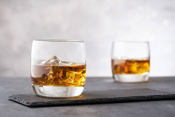 whiskey de plan rapproché avec des glaçons - shot glass glass black empty photos et images de collection