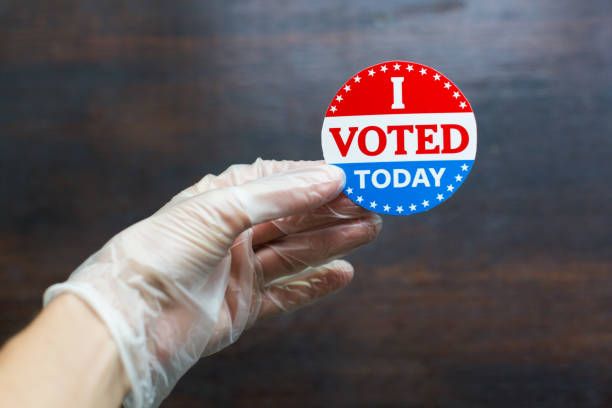 istock Hand wearing surgical glove holding I voted today sticker 1258006013