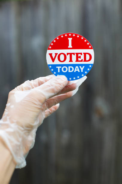 istock Hand wearing surgical glove holding I voted today sticker 1258006685