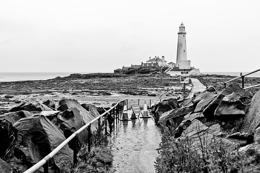 Whitley Bay, UK. St Mary's lighthouse causeway showing traffic cones and a closed sign on the footpath to the causeway due to coronavirus lock down.
