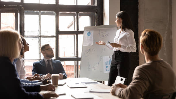 istock Confident young female coach present project at meeting 1258010029