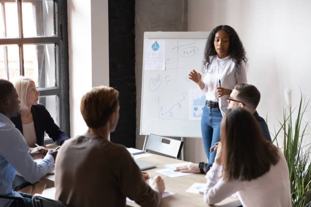 istock Biracial female speaker present business project on flip chart 1258010030