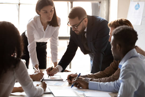 istock Diverse colleagues talk discuss business project together at meeting 1258010064
