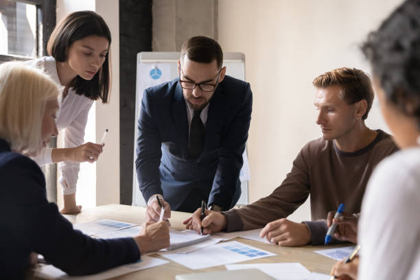 istock Multiracial coworkers brainstorm discuss paperwork at briefing 1258010076