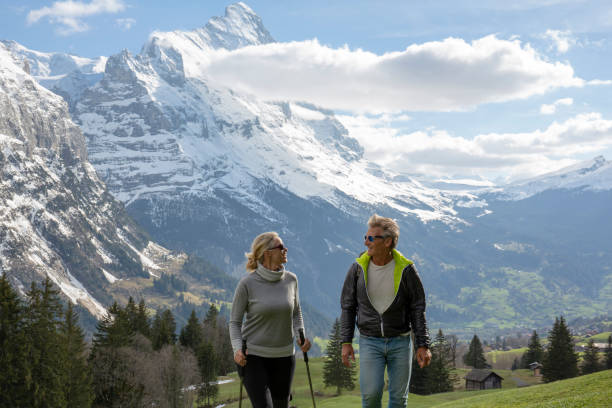 istock Hiking couple walk through grassy meadow in spring 1258010412