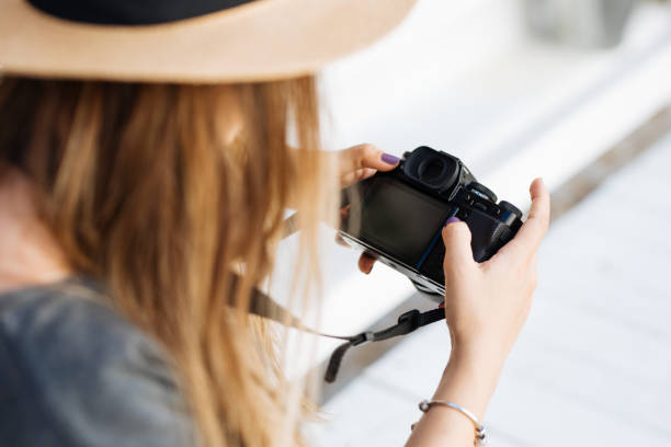 istock Young female photographer checking her camera 1258012882