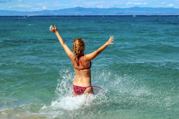 istock Young Woman enjoying a day at the beach 1258013916