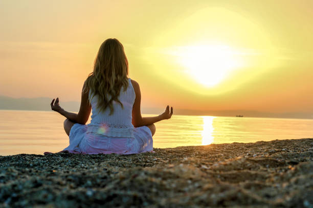 istock Woman doing yoga on the beach 1258013931