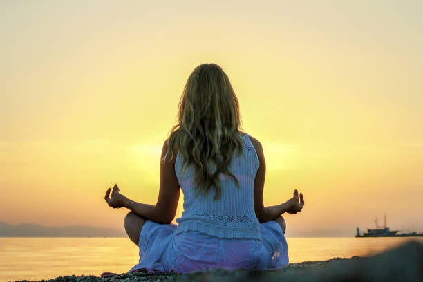 istock Woman doing yoga on the beach 1258013954
