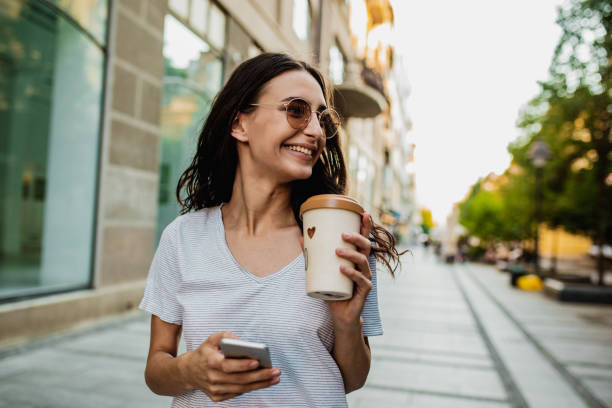 istock Young woman in the city with reusable coffee cup 1258016421