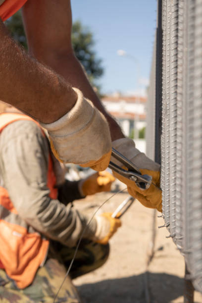 istock Only hands. Using steel wire for securing steel bars with wire rod for reinforcement of concrete or cement 1258020413