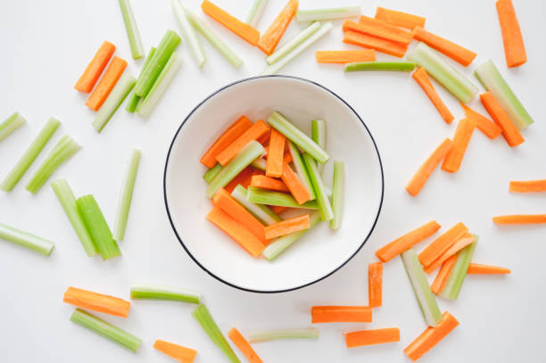istock Sliced carrots and celery in a white bowl, healthy food background 1258024802