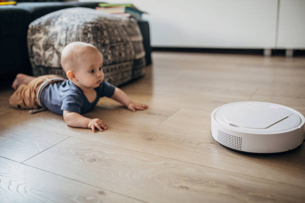 istock Baby boy playing at home and discovering robotic vaccum cleaner 1258025984