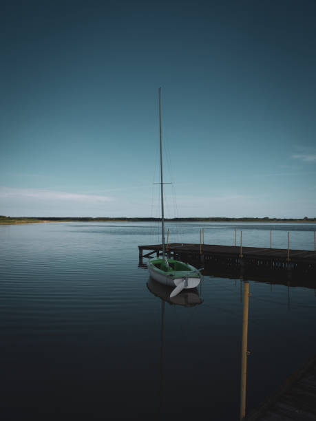 pequeno veleiro verde é anexado a um lago em um estágio de pouso - plank boardwalk pontoon bridge summer - fotografias e filmes do acervo