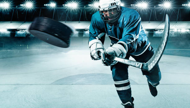 ishockey spelare idrottsman i hjälmen och handskar på stadion med pinne. action skott. sport koncept. - hockey bildbanksfoton och bilder