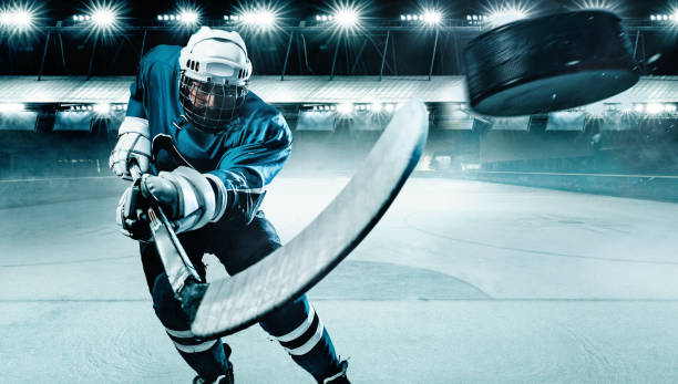 Ice Hockey player athlete in the helmet and gloves on stadium with stick. Action shot. Sport concept. stock photo