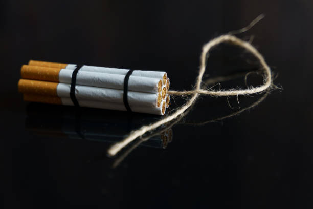 istock Cigarettes are twisted into a dynamite checker with a filament on a black reflective surface. 1258030967