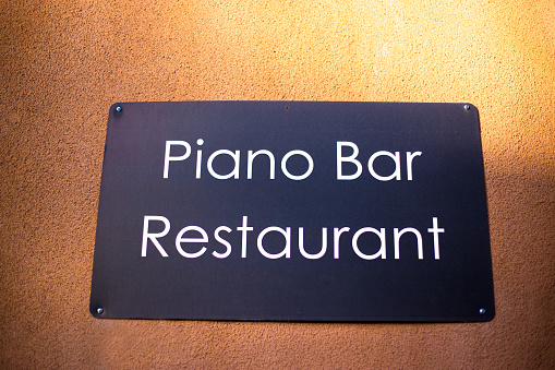 Sign on Orange Wall: Piano Bar/Restaurant