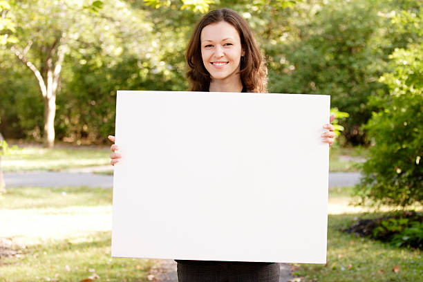 istock Young Woman Holds Blank White Sign 125803929