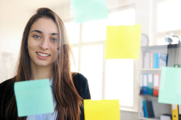 istock Beautiful business woman looking at sticky notes 1258043900